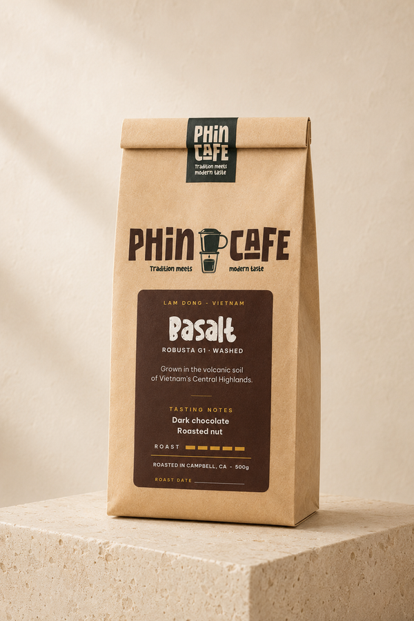 Basalt — 500g kraft bag of Phin Cafe Vietnamese robusta coffee with a dark brown label, on a stone plinth