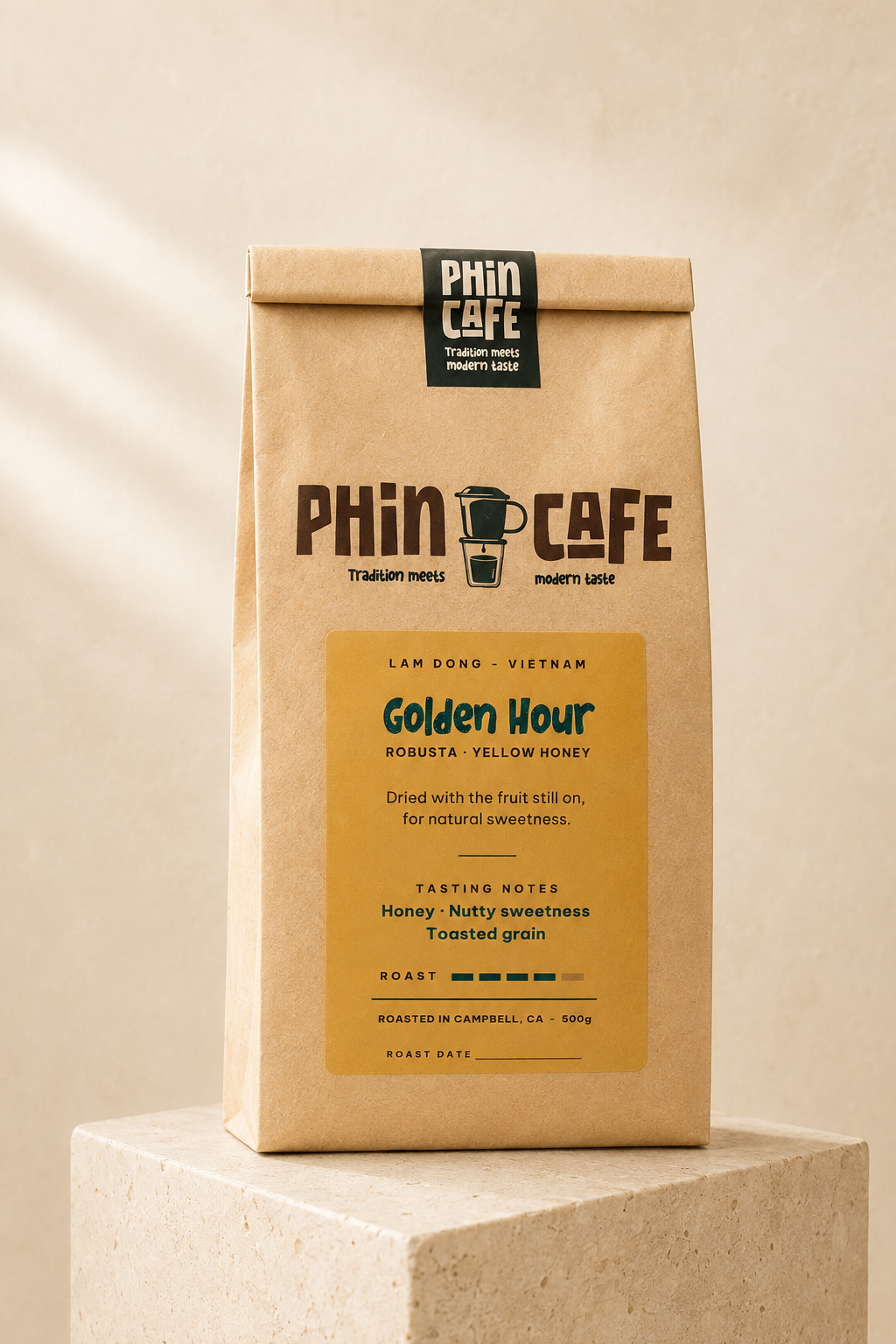 Golden Hour — 500g kraft bag of Phin Cafe yellow honey robusta coffee with a golden label, on a stone plinth