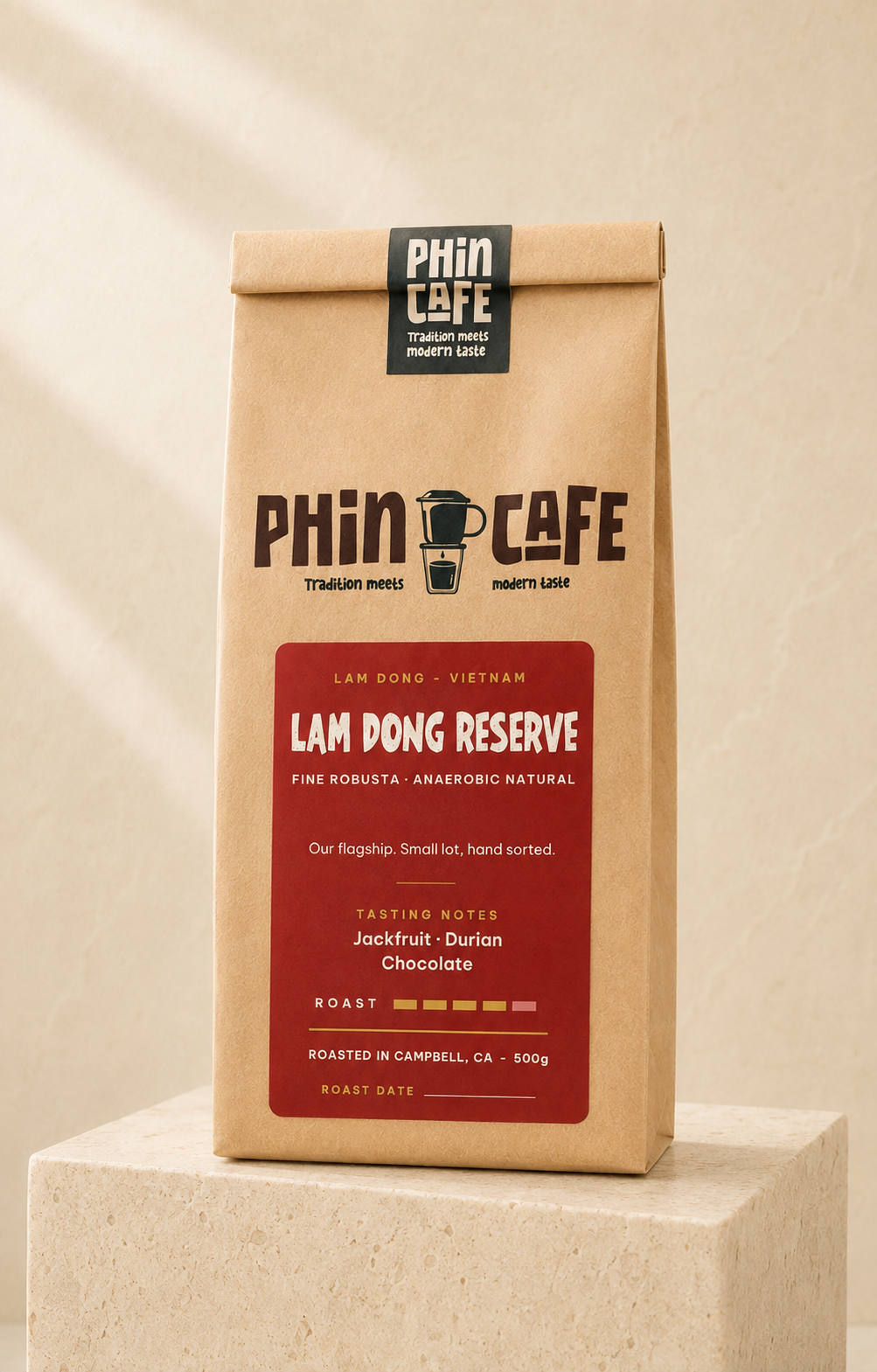Lam Dong Reserve — 500g kraft bag of Phin Cafe anaerobic natural fine robusta coffee with a red label, on a stone plinth