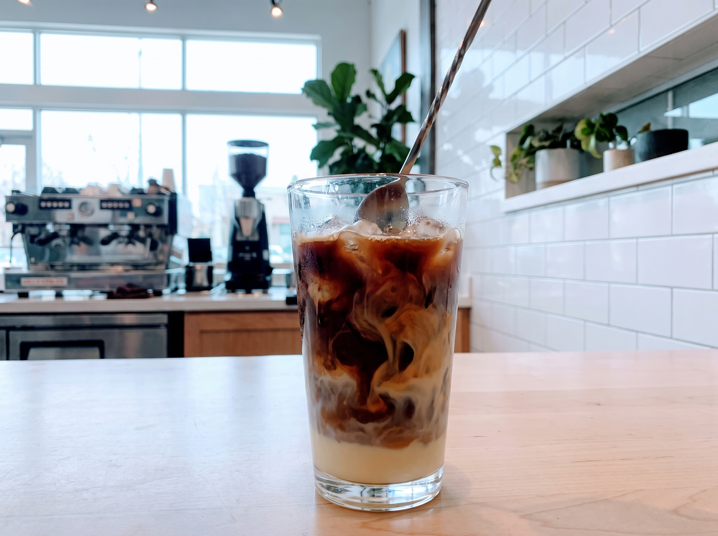 Coffee stirred into condensed milk over ice